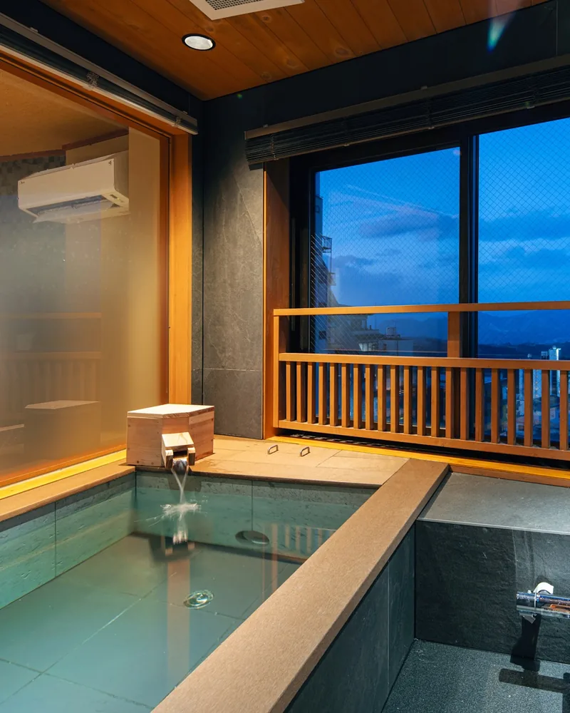 The indoor bath at dusk, with a view of the town